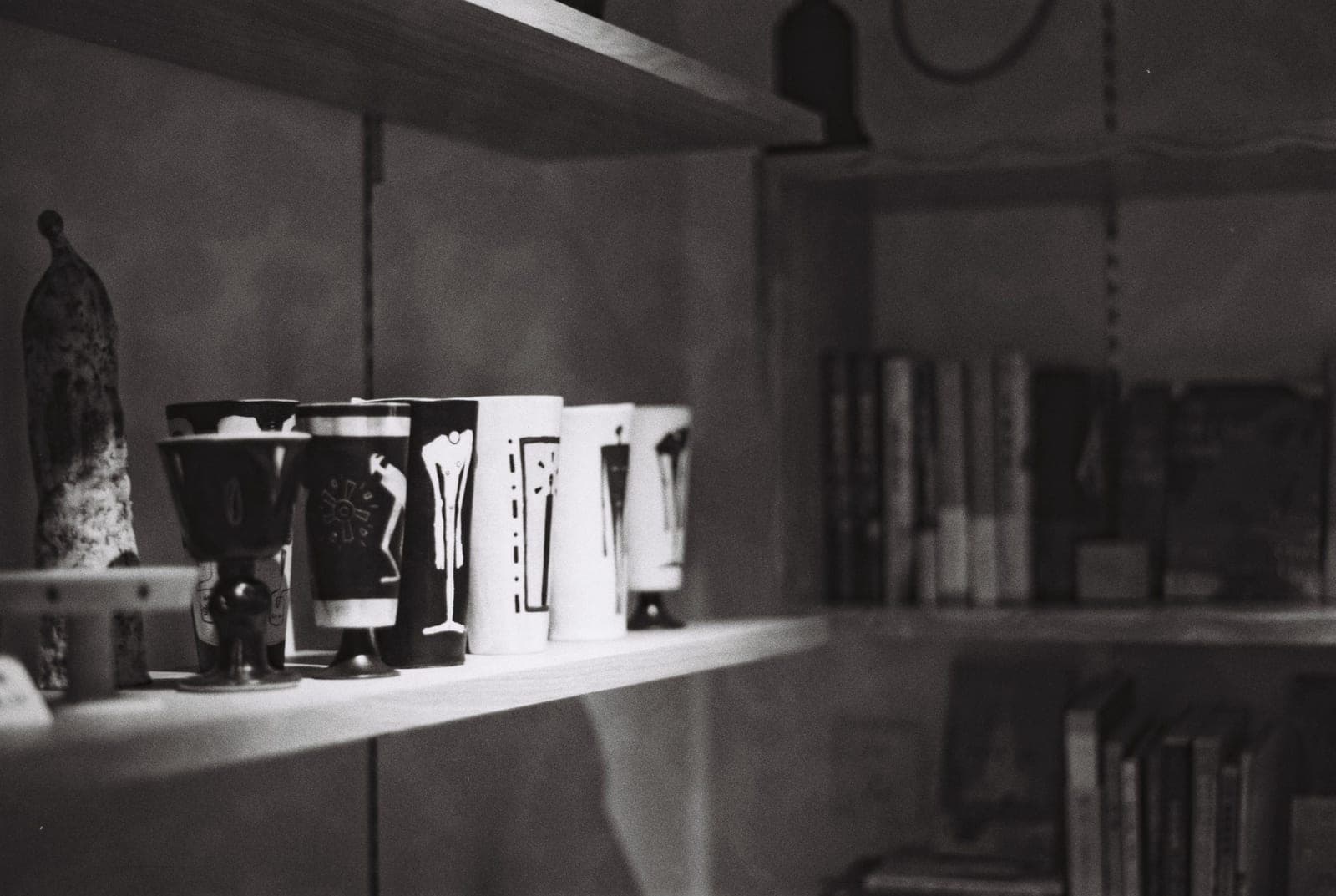 Decorative ceramic cups arranged on a pair of open shelves