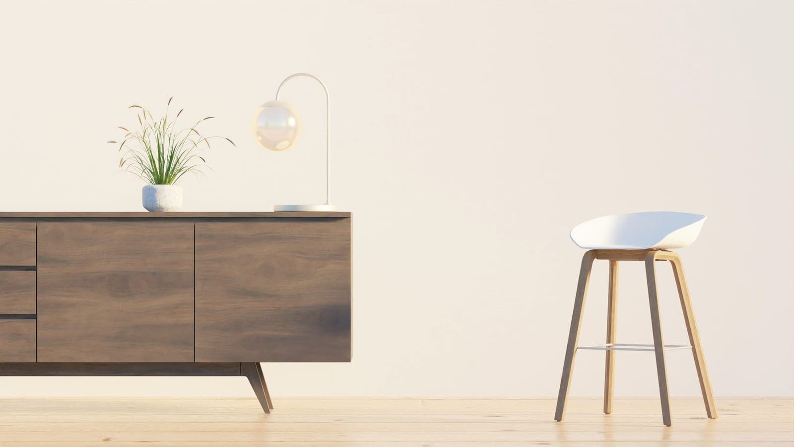 A small lamp on a wooden sideboard beside a pale chair