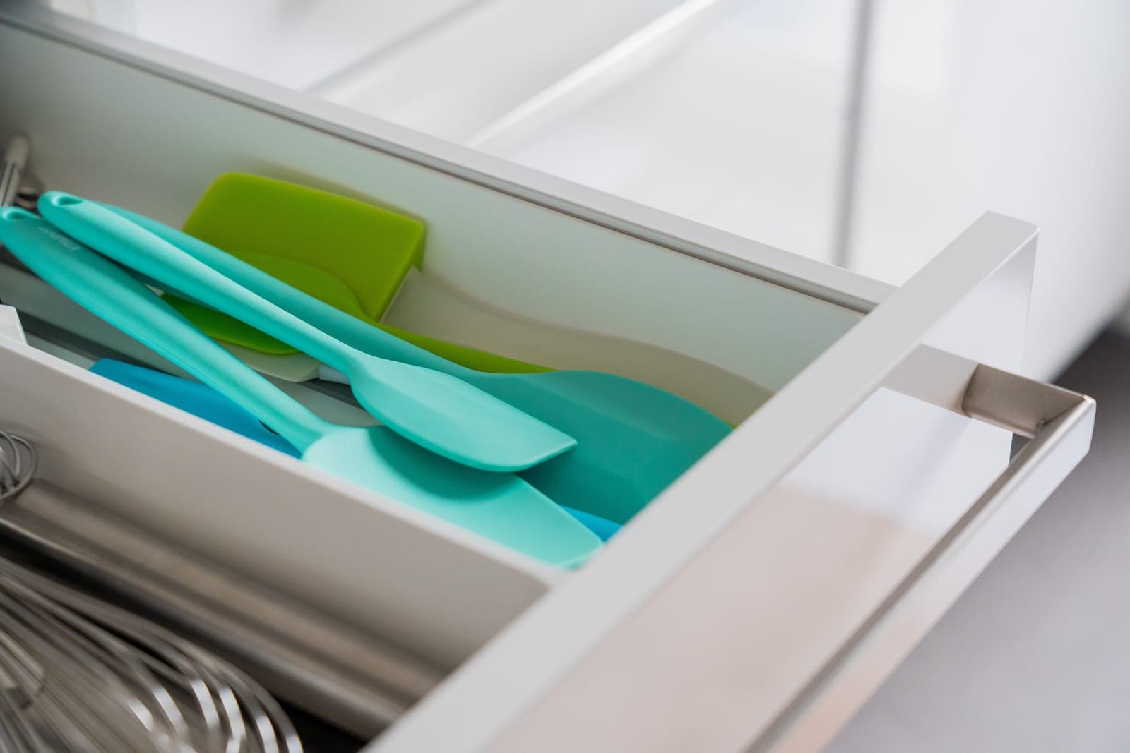Silicone kitchen utensils laid out on a white surface