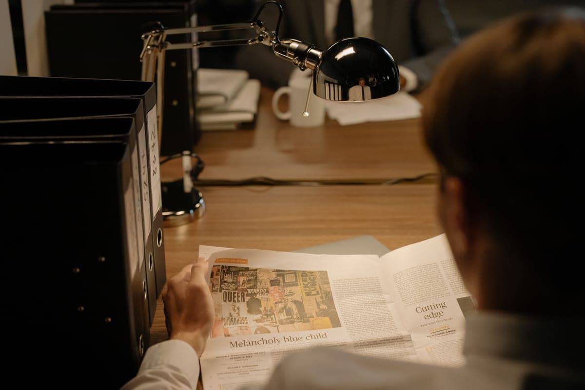 A person reading a printed document at a desk