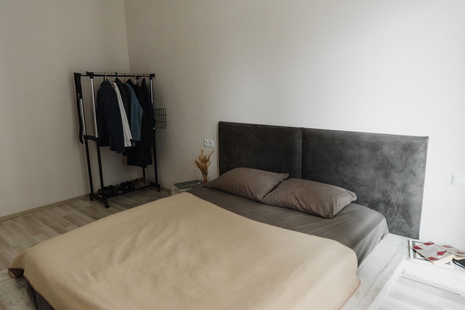 A neatly made bed in a room with neutral bedding