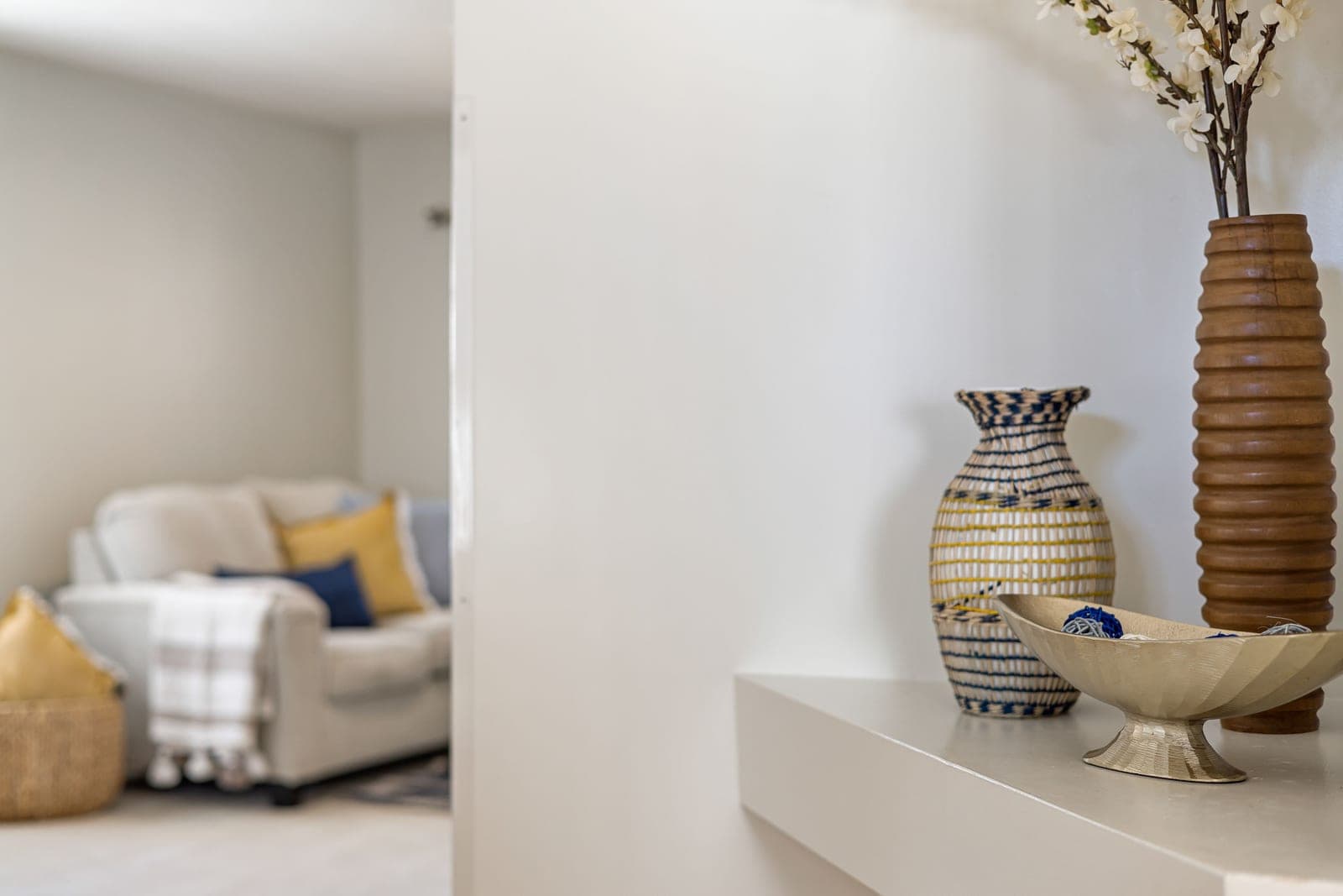 A neutral living-room shelf with a vase and small objects