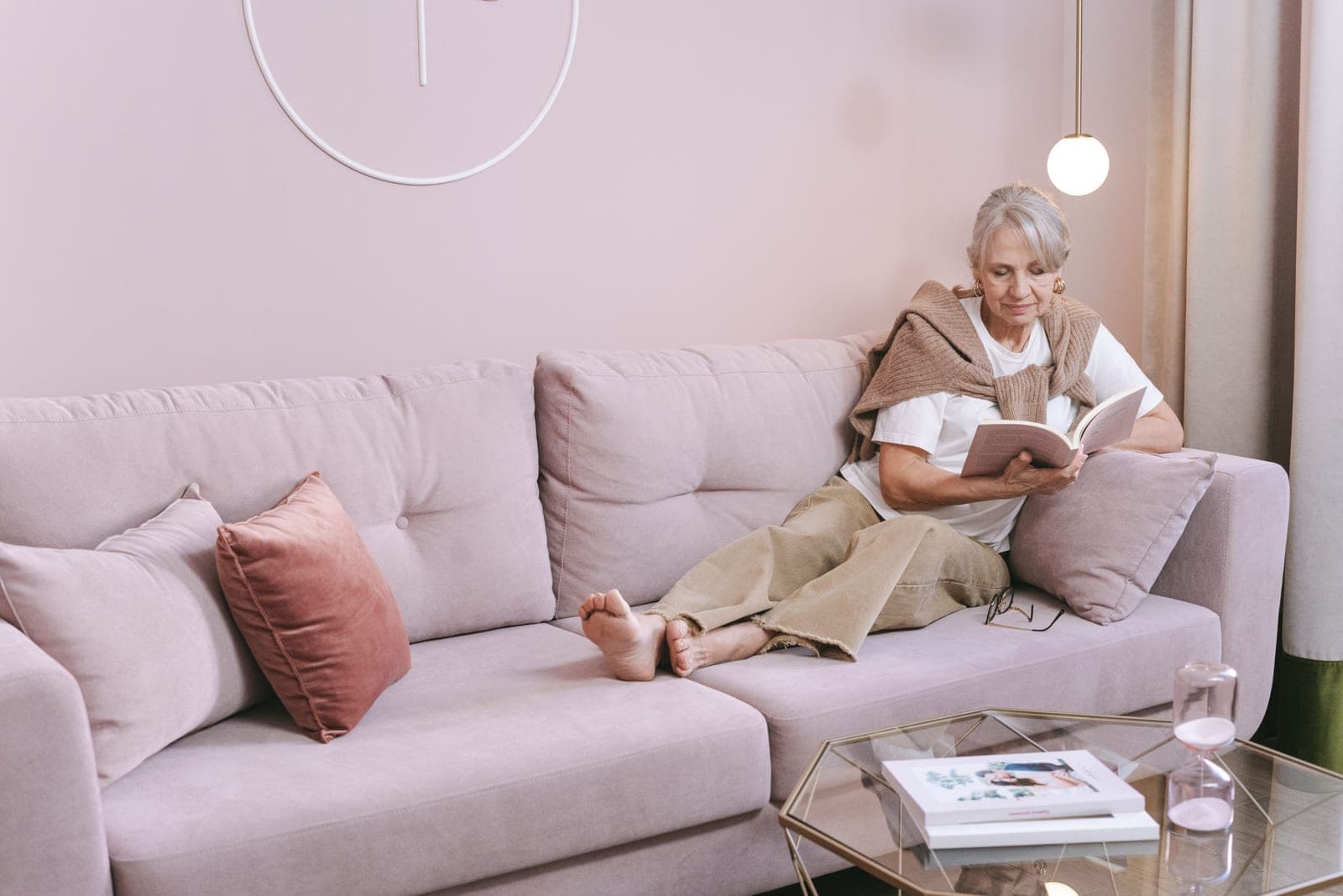A person relaxing with a book on a sofa in a living room