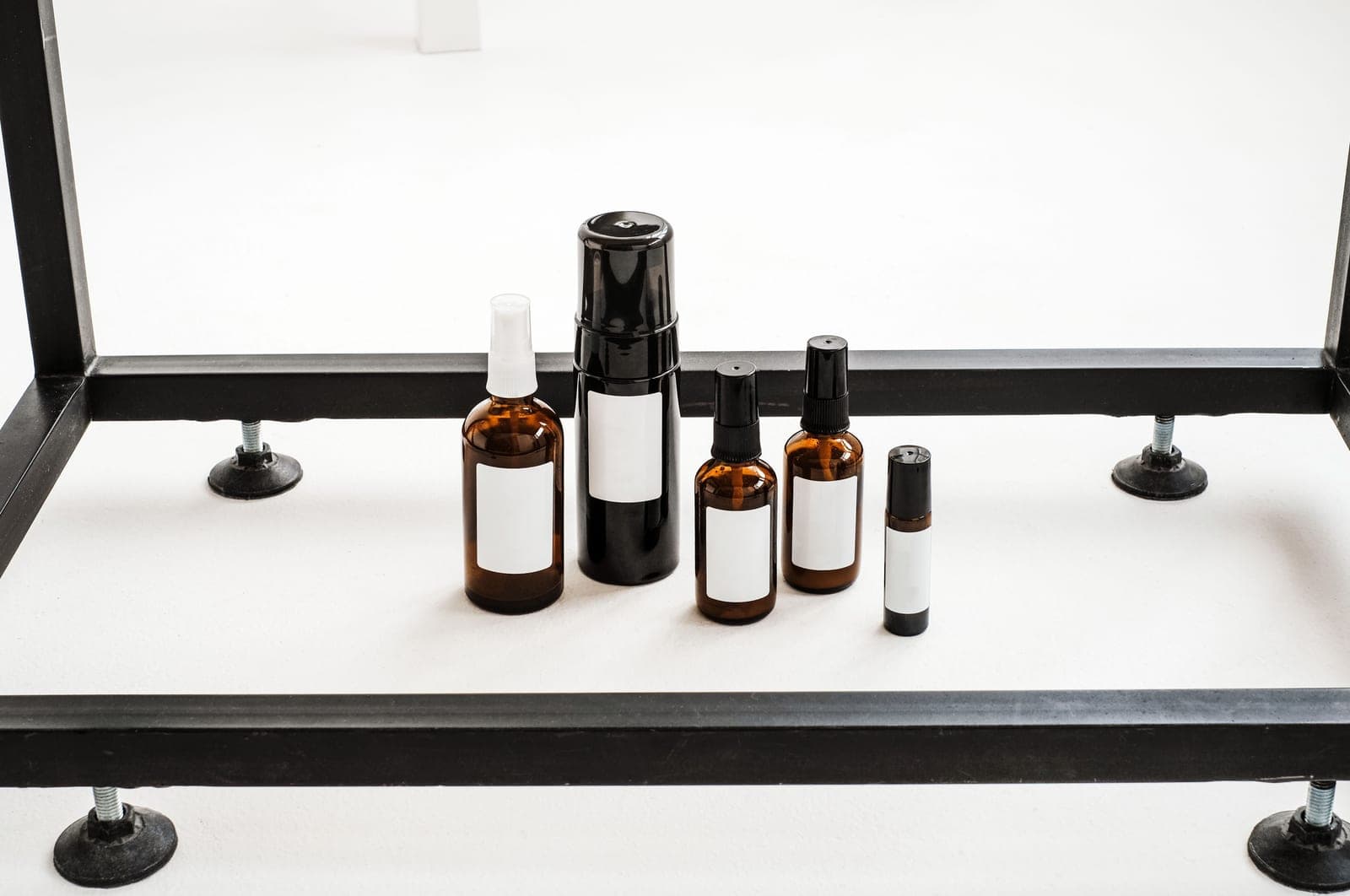 Amber and dark glass bottles arranged on a white table